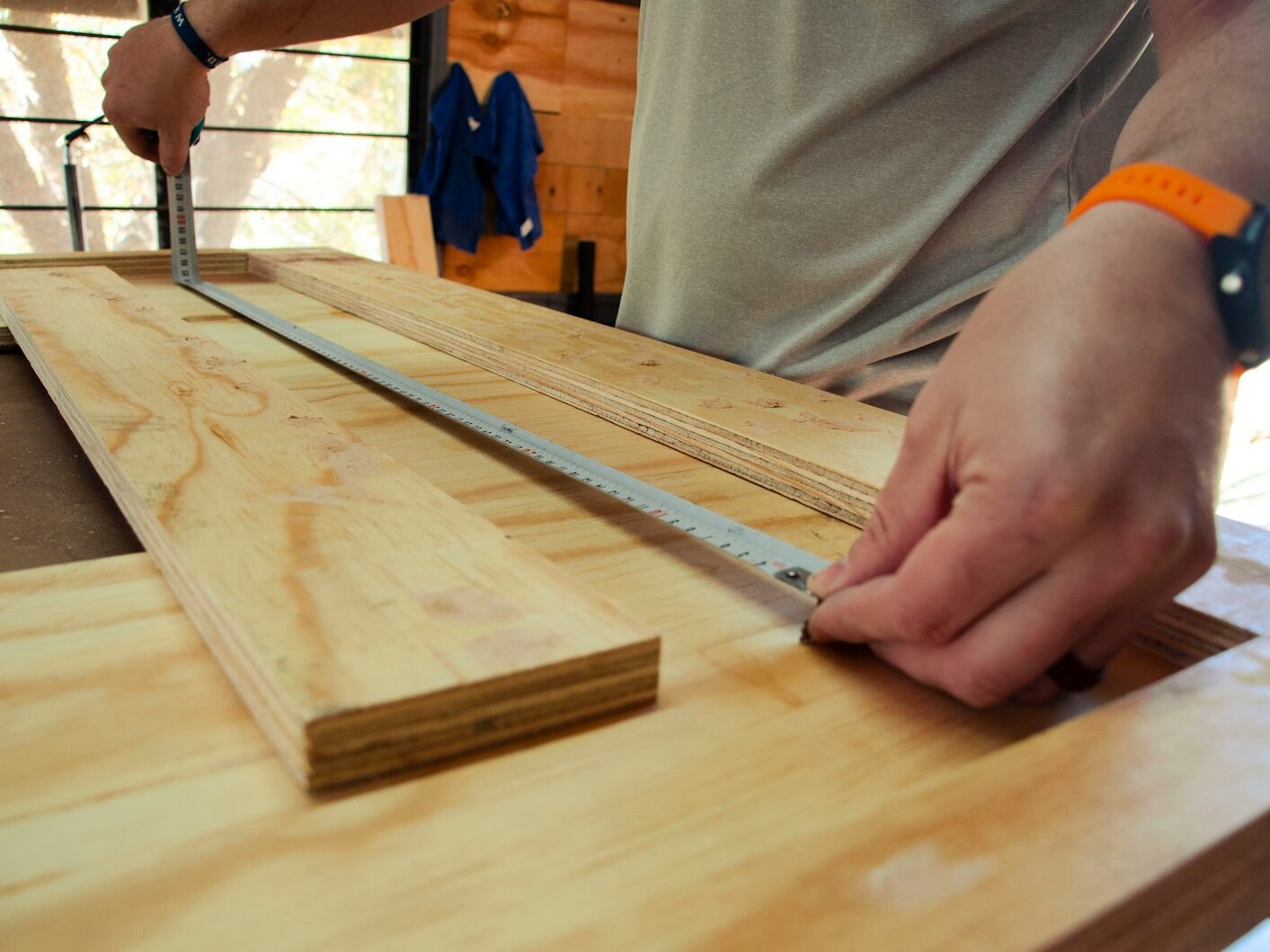 person in white shirt holding brown wooden table